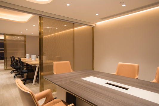 工程案例的新蒲崗辦公室項目設有一間現代化的會議室,配有木桌、棕褐色椅子和玻璃隔間,相鄰區域配有配備電腦和椅子的辦公桌。.