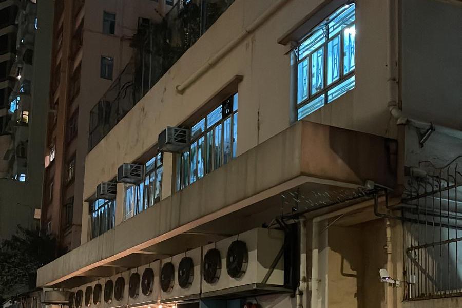 夜晚的城市街道,背景是宣傳裕利工程的建築物。