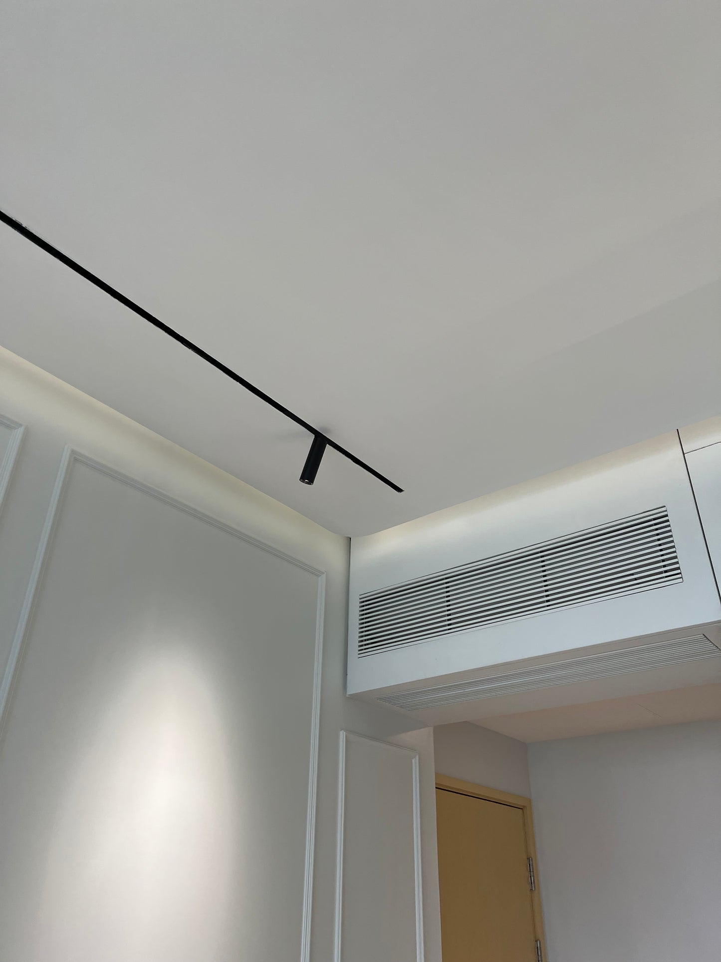 房間的天花板是白色的，配備的是裕利工程品牌的黑色空調。