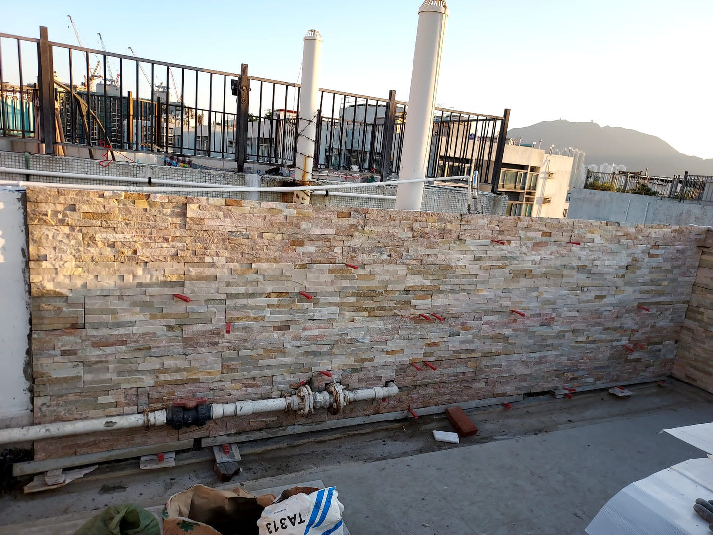 裕利工程的觀塘大廈天台防水工程的建築物一側正在建造磚牆。
