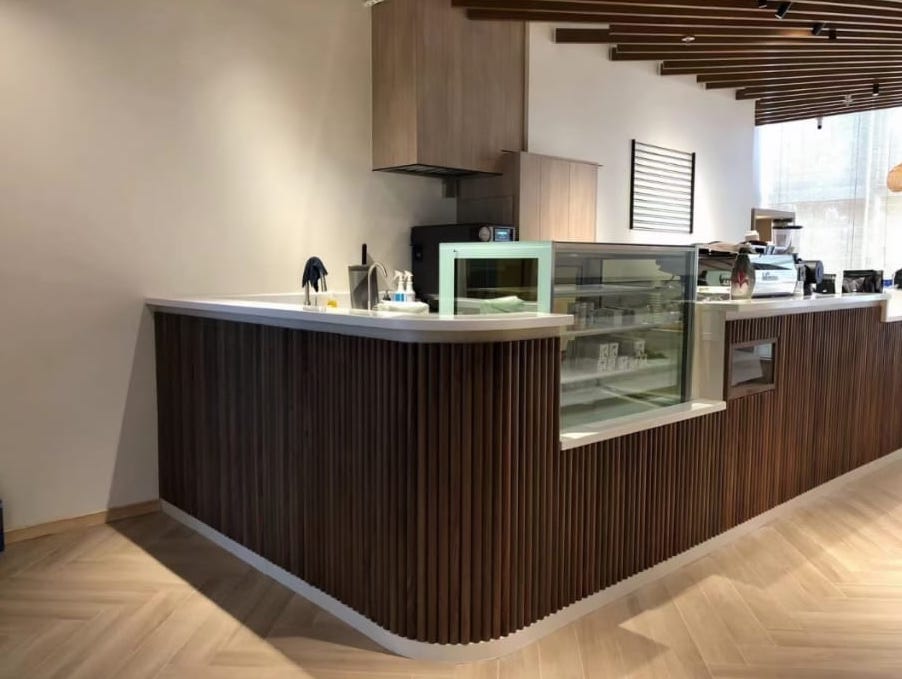 由裕利工程設計的九龍灣咖啡店，木質櫃檯和木地板。