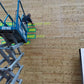 一名男子站在梯子上正在粉刷木牆，這是裕利工程的一部分。