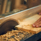 一個人正在使用裕利工程手鋸切割一塊木器工程。